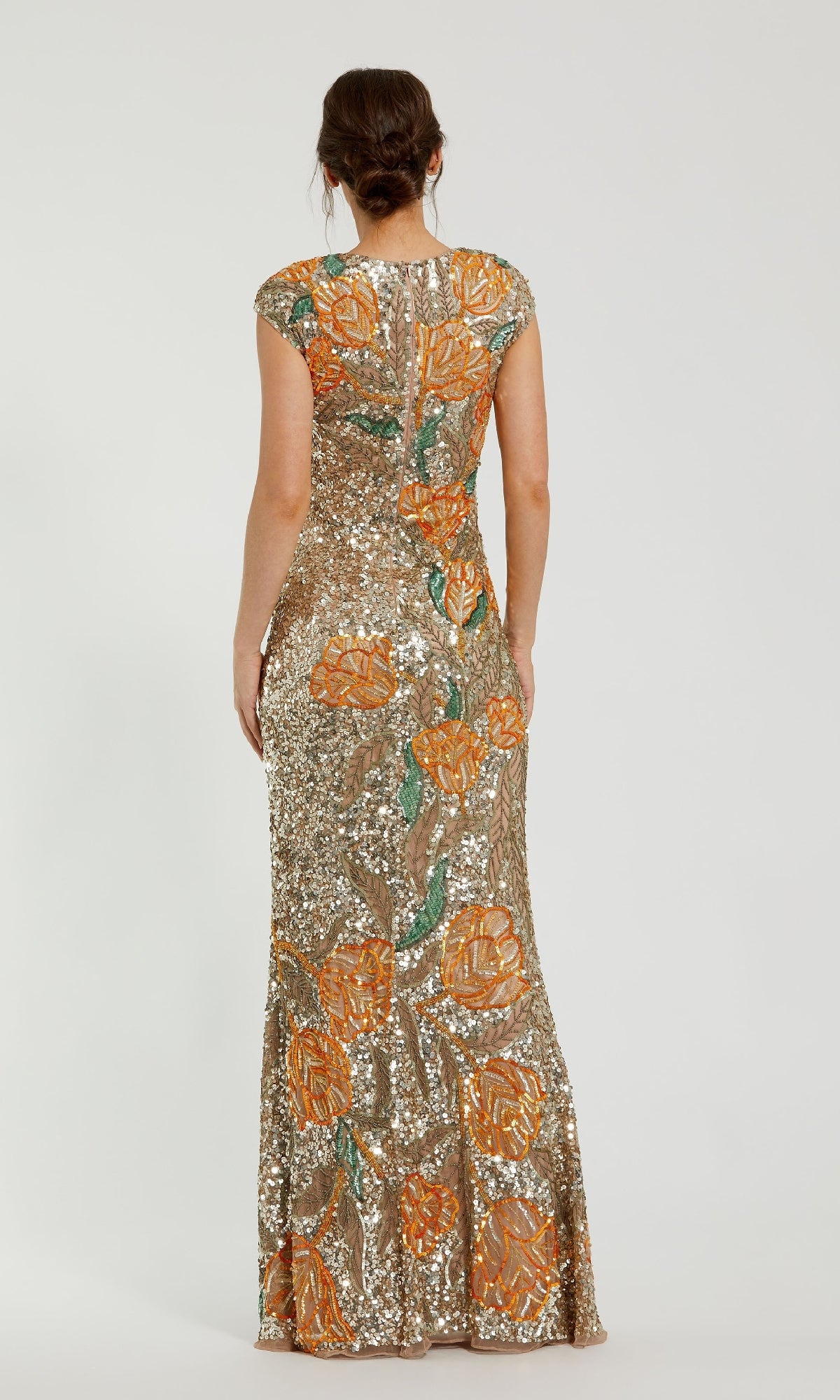 Woman with her back to the camera wears the Mac Duggal 6121, a fitted, floor-length gold formal dress featuring orange floral patterns, sequin accents, and elegant cap sleeves.