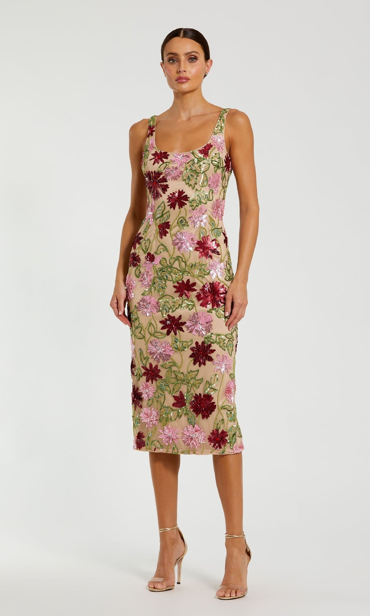 A woman wears the Beaded Midi Wedding Guest Dress: Mac Duggal 6124, featuring red, pink, and green sequins with nude heels—an elegant option for a nude wedding guest dress—posed before a plain background.