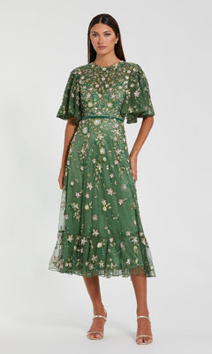 Woman wearing a green floral dress on a white background