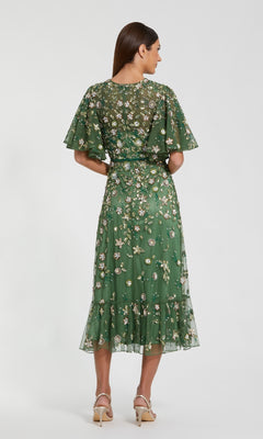 Woman wearing a green floral dress on a white background