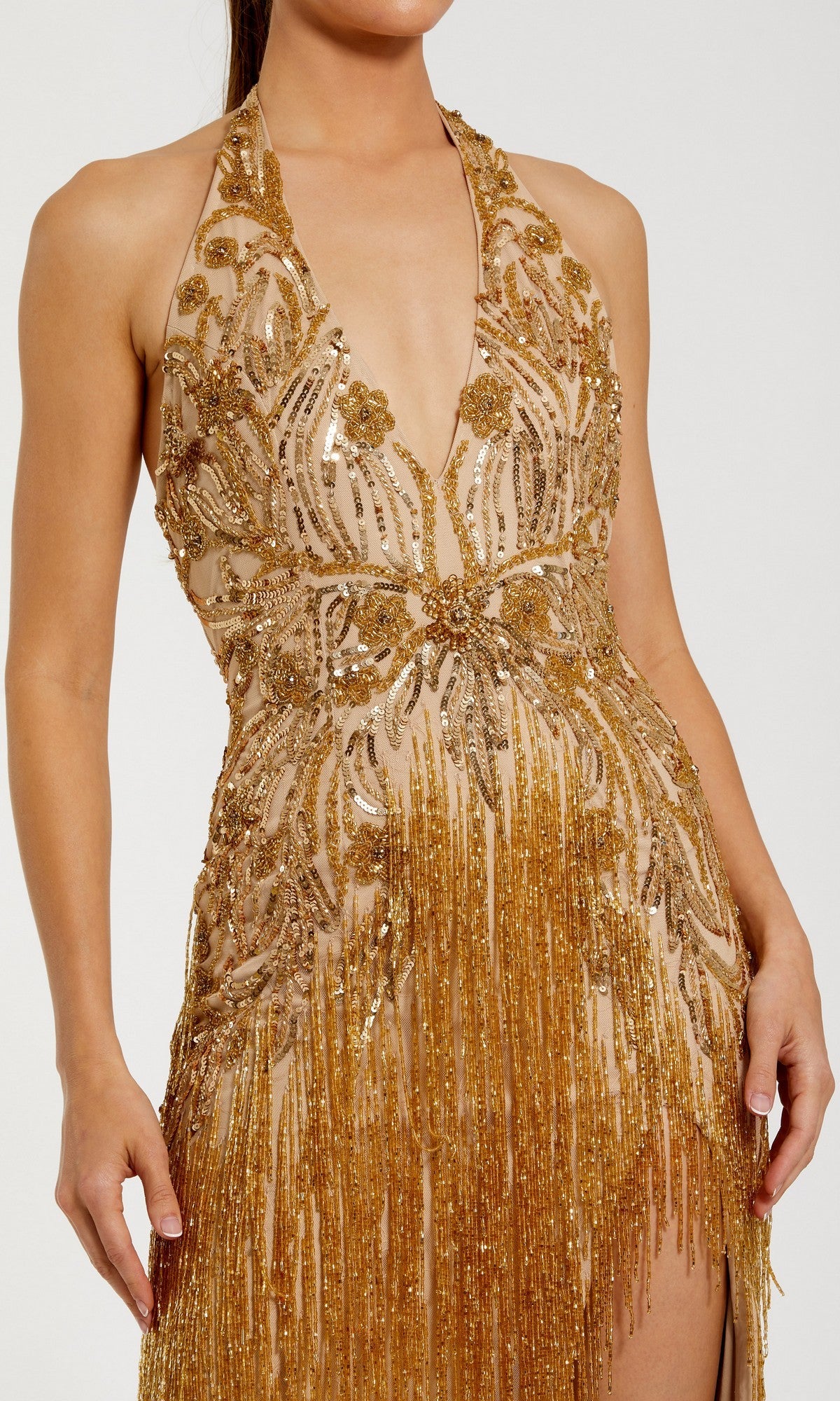 A woman wearing the Mac Duggal 6170 Long Formal Dress, a sleeveless gown adorned with gold sequins, featuring a plunging neckline and sophisticated fringe accents.