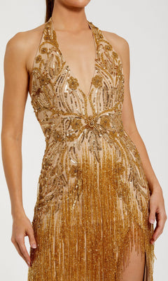 A woman wearing the Mac Duggal 6170 Long Formal Dress, a sleeveless gown adorned with gold sequins, featuring a plunging neckline and sophisticated fringe accents.