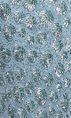 Close-up of the Long Prom Dress: Blondie Nites 6171BN, showcasing textured fabric with metallic silver and teal raised circles and beadwork on a light blue background—perfect for prom.