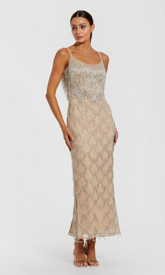 A woman wearing the Mac Duggal 6172 long formal dress in Nude Silver, a sleeveless midi design adorned with shimmering fringe and sequin details, stands in heels against a plain white background.
