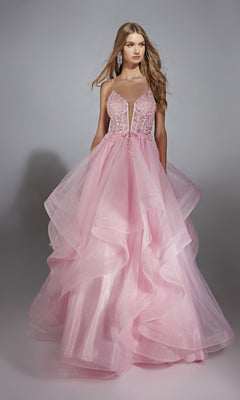 A woman stands against a gray background wearing the Alyce 61731 Long Prom Dress, a pink ball gown with a voluminous skirt and fitted beaded bodice with spaghetti straps.