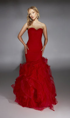 A woman wears the Alyce 61739 long prom dress featuring a strapless mermaid silhouette, sweetheart neckline, and ruffled tulle skirt, set against a plain gray background.