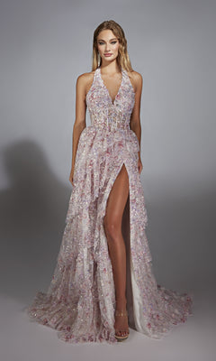 A woman poses in a studio wearing the Alyce 61740 long prom dress—a sleeveless, floor-length gown with a high slit and sheer sparkly floral design in pale pink and lavender.