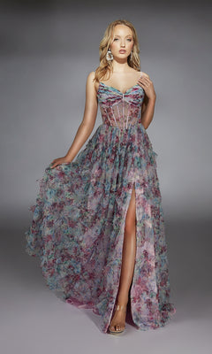 A woman stands against a plain gray background wearing the Long Prom Dress: Alyce 61748, featuring a sheer corset bodice, spaghetti straps, and a high-leg slit.