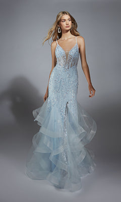 A woman wearing the Alyce 61749 long prom dress—a light blue, floor-length gown with a plunging neckline, sheer panels, sequin embellishments, a lace-up corset bodice, and layered ruffled tulle at the hem.