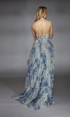 A woman faces away from the camera, wearing the Alyce 61753 long prom dress with a strapless sheer bodice and a blue-and-white tiered A-line skirt accented with delicate ruffles.