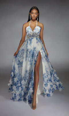 A woman poses in the floor-length Alyce 61757 long prom dress, featuring blue floral patterns, a sheer bodice, and a high leg slit.