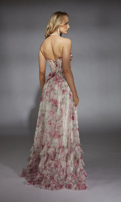 A woman faces away, wearing the Alyce 61757 Long Prom Dress—a strapless, floor-length gown with a floral pattern and ruffled hem—against a plain gray background.