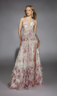A woman poses against a gray background in the Alyce 61757 long prom dress, featuring a sleeveless floral-print design with a halter neckline, sheer bodice, and ruffled hem.