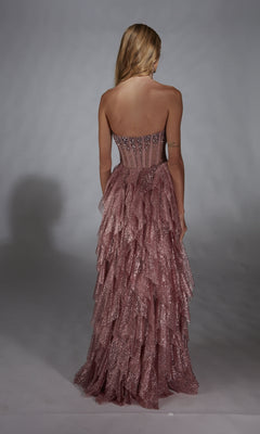 A woman faces away, wearing the Alyce 61762 Strapless Long Glitter A-Prom Dress with a tiered ruffled skirt, set against a plain backdrop.