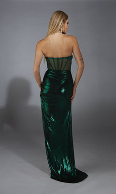 A woman faces away, modeling the Alyce 61784 long prom dress—a strapless metallic gown with a sheer corset bodice and floor-length dark green fabric—set against a plain gray background.