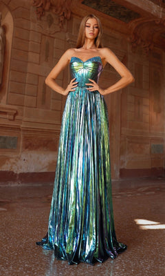 A woman stands in an ornate hallway wearing the Alyce 61786 Strapless Pleated Metallic Prom Gown, featuring an iridescent finish, pleated skirt, and fitted bodice.