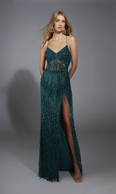 A woman models the Alyce 61788 long prom dress—a sleeveless, dark green beaded fringe gown with a sheer midsection, high slit, and spaghetti straps—against a plain gray background.