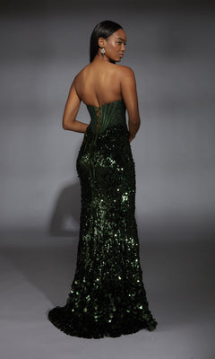 A woman stands facing away, wearing the Alyce 61796 Strapless Long Sequin Prom Dress featuring a fitted corset-style bodice and a lace-up back.