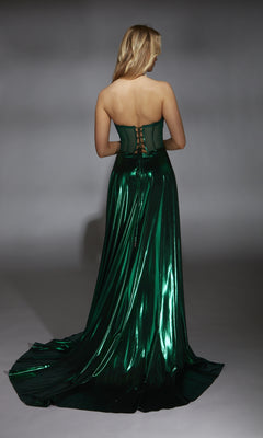A blonde woman faces away, wearing the Alyce 61797 long prom dress in emerald green with a strapless metallic design, corset bodice, lace-up back, and a flowing train.