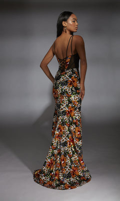 A woman wears the Alyce 61809 long prom dress with floral sequin accents, black sheer back, and thin straps, standing in a studio facing away.