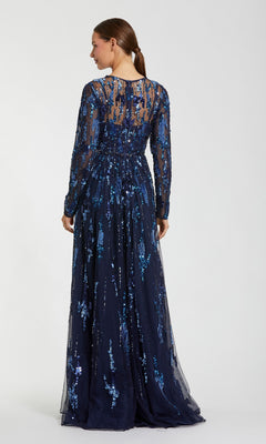 A woman is seen from behind wearing the Long Formal Dress: Mac Duggal 6181—a long-sleeved navy gown embellished with blue sequins and sheer accents—standing against a plain light background.