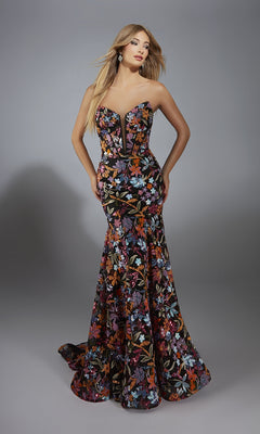 Woman models the Alyce 61810 long prom dress, featuring a strapless mermaid silhouette with a fitted corset bodice and bright sequin flower print, posing against a plain gray background.
