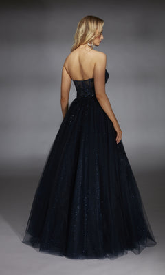 A woman is seen from the back against a gray background, wearing the Alyce 61846 Strapless Long Glitter Prom Ball Gown with a shimmering tulle skirt.