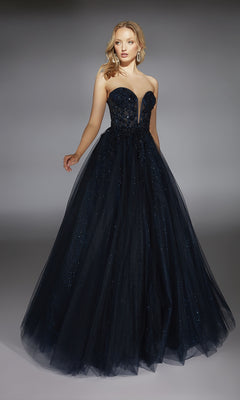 A woman stands against a gray background wearing the Alyce 61846 Strapless Long Glitter Prom Ball Gown, featuring a fitted bodice and tulle floor-length skirt.