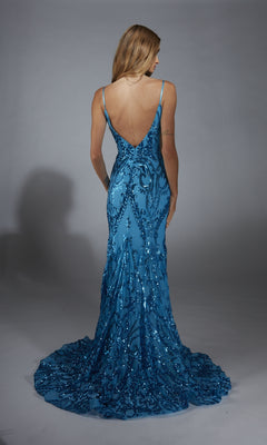 Wearing the Alyce 61852 long prom dress, a woman in a floor-length blue sequin gown with a deep V-back stands facing away against a plain gray background.