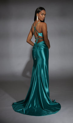 A woman poses against a gray background in the Alyce 61875 long prom dress, featuring teal satin fabric, a backless crisscross strap design, and a floor-length train as she looks over her shoulder.