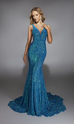 A woman stands against a plain gray background wearing the Alyce 61876 long prom dress, a form-fitting blue gown adorned with sparkling sequins.