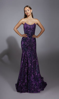 A woman stands on a gray backdrop wearing the Alyce 61887 long prom dress, a strapless mermaid gown in dark purple with shimmering embellishments on the fitted bodice and a flared sequin skirt.