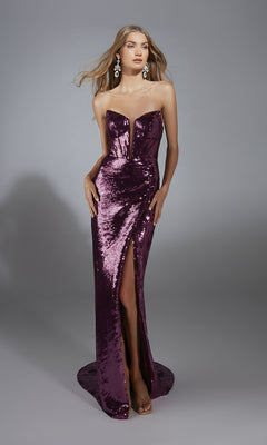 A woman poses in the Alyce 61888 long prom dress, featuring a strapless sequin design, corset bodice, sweetheart neckline, thigh-high slit, and statement earrings against a gray background.