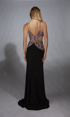 A woman faces away, wearing the Alyce 61902 long prom dress in black with purple and silver accents, a butterfly back cut-out, and a subtle leg slit.