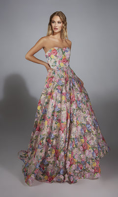 A woman models the Alyce 61913 Long Prom Dress, a strapless, floor-length floral-printed gown, against a plain gray background.