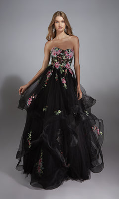 A woman models the Alyce 61914 long prom dress, featuring a strapless bodice, full tulle skirt, and vibrant floral embroidery, against a plain gray background.