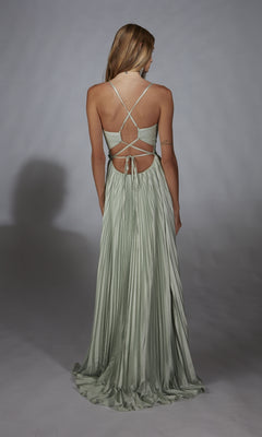 A woman faces away, wearing the Alyce 61923 long prom dress featuring floor-length satin chiffon, a pleated A-line skirt, crisscross straps, and an open back.