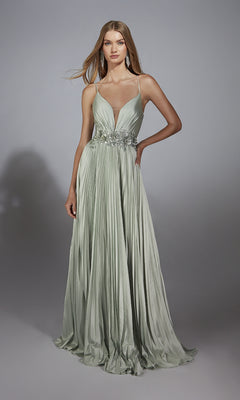 A woman models the Alyce 61923 long prom dress, featuring a light green satin chiffon A-line skirt with pleats, spaghetti straps, and floral waist accents, standing before a plain gray background.