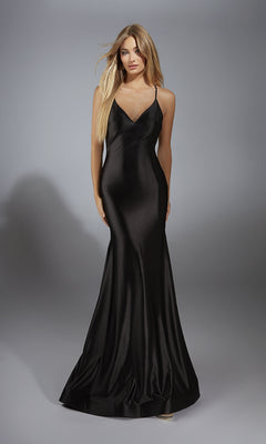 A woman wears the Alyce 61966 long prom dress, a floor-length black satin gown with thin straps, a v-neckline, and a fitted silhouette, standing against a neutral background.