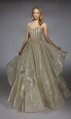 A woman wears the Alyce 61971 long prom dress, showcasing a strapless beaded corset bodice and a floor-length gold glitter skirt with voluminous layers.