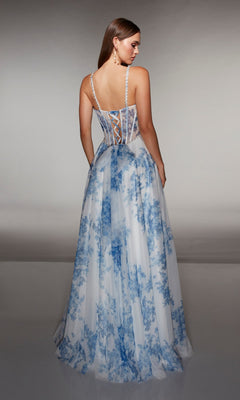 Woman in a floor-length, sleeveless Alyce 61994 prom dress with blue floral patterns and a lace-up corset bodice, standing and facing away from the camera.