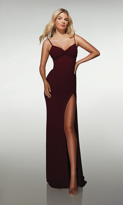 A woman stands before a plain light background in the Alyce 62002 Long Prom Dress—a sleeveless, dark red evening gown featuring a corset bodice and high slit.