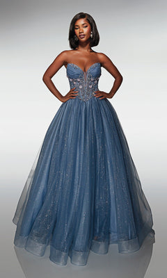A woman stands with hands on hips, wearing the Alyce 62009 long prom dress featuring a strapless corset bodice, blue 3D flower appliqué, and a full sparkling glitter tulle ball gown skirt.