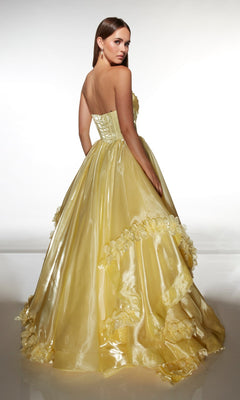 A woman wearing the Alyce 62014 Long Prom Dress, a strapless ballgown in liquid organza with 3D floral appliques, stands facing away and glances over her shoulder.