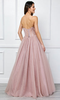 Woman modeling the back of a dusty rose pink ball gown in front of a white wall.