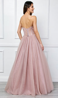 Woman modeling the back of a dusty rose pink ball gown in front of a white wall.