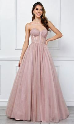 Woman wearing a strapless pink ball gown against a white wall