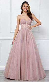 Woman wearing a strapless pink ball gown against a white wall