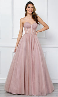 Woman wearing a strapless pink ball gown against a white wall