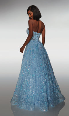A woman stands with her back to the camera wearing the Alyce 62033 long formal dress, featuring a strapless beaded corset bodice, floor-length light blue skirt, and sequin lace details.